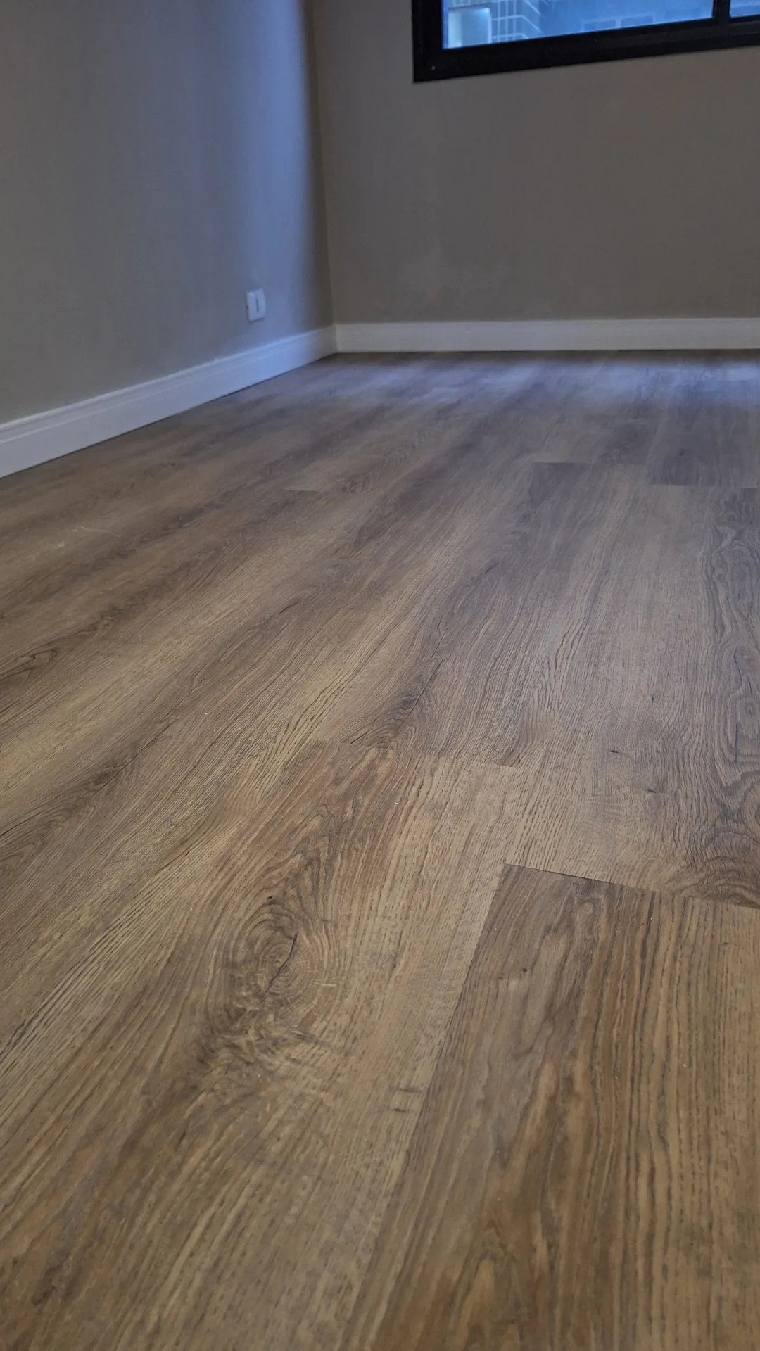 Piso amadeirado em sala com porta de vidro